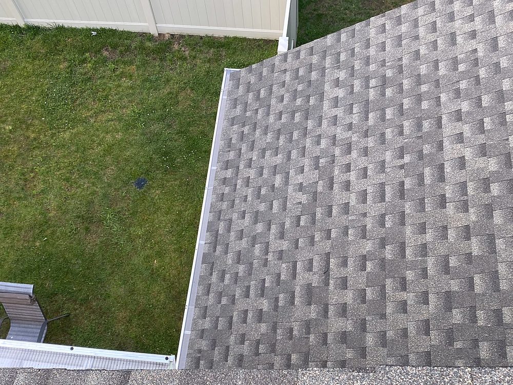 New seamless gutters with a gutter guard installed along a residential roof edge
